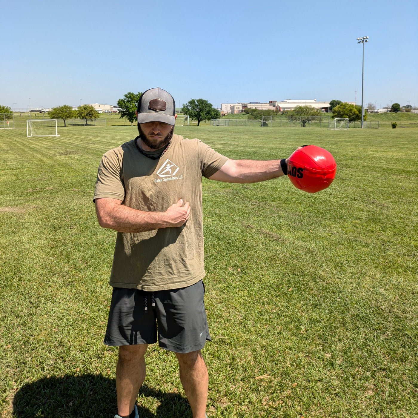 Athlete using a water-filled mini aqua ball at their side for dynamic shoulder warm-up and arm strengthening, demonstrating perturbation training for shoulder activation.