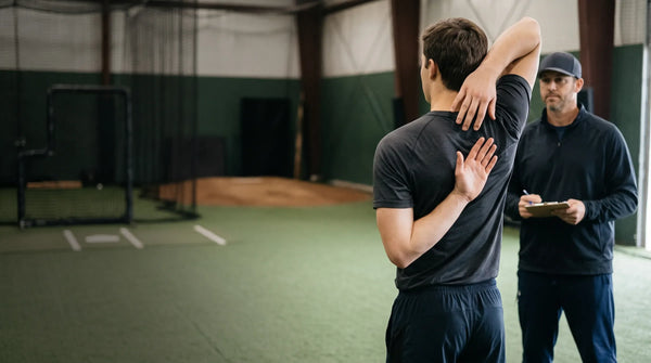Coach completes mobility screening for an athlete's shoulders.