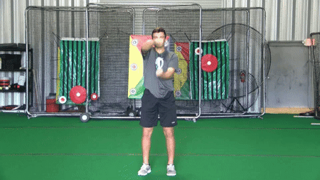 Athlete performing shoulder and scapular activation using a Green Exercise Band as part of dynamic warm-up before training or competition.
