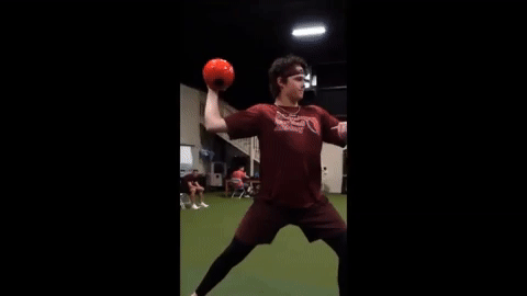 Athlete at Florida Baseball ARMory performing full pitching motion while shaking a water-filled mini sphere, enhancing shoulder stability and control.
