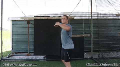 Athlete performing throwing motion exercise with Shoulder Sphere to strengthen rotator cuff and improve shoulder stability.