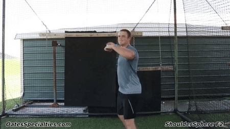 Athlete performing throwing motion exercise with Shoulder Sphere to strengthen rotator cuff and improve shoulder stability.