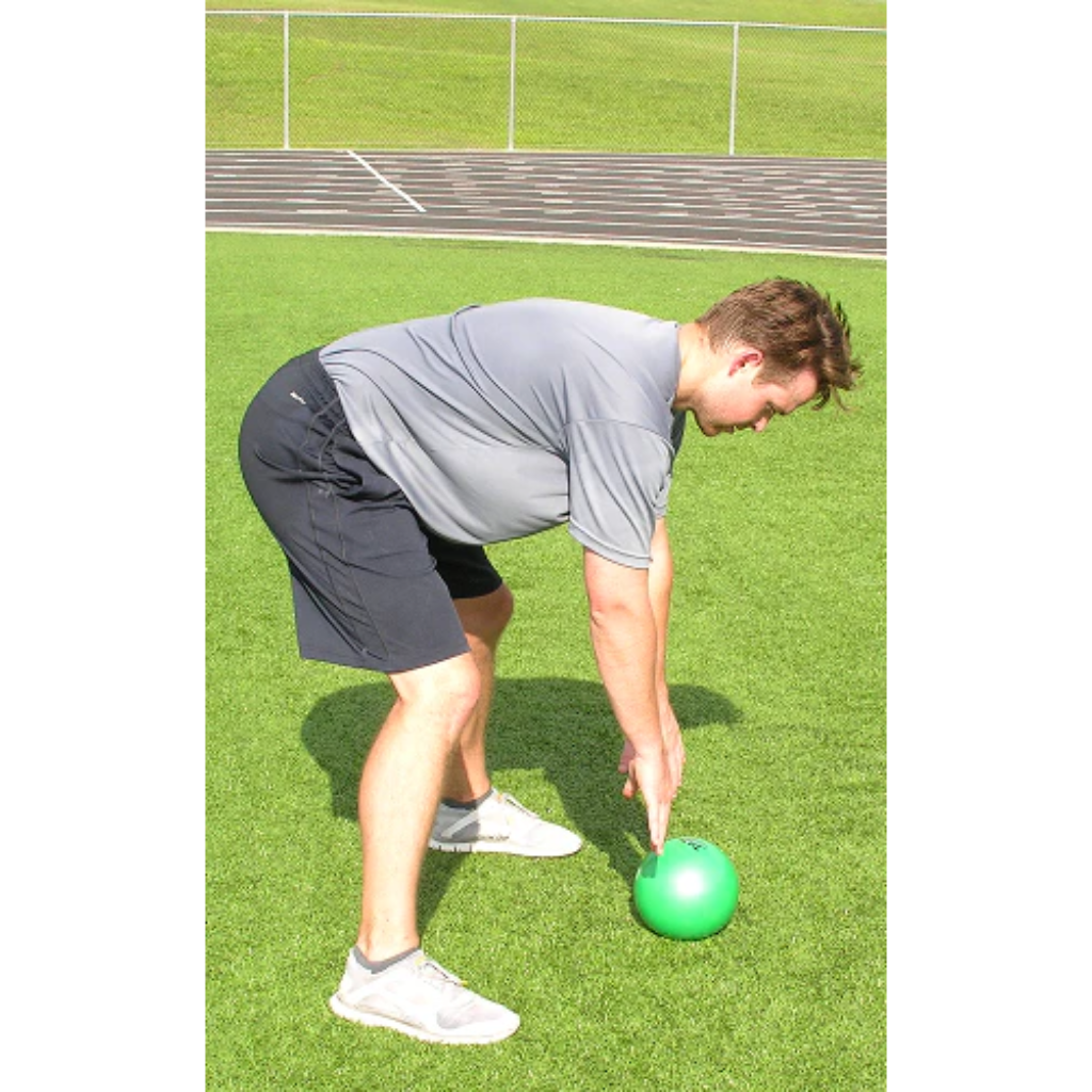 The green pummel ball rests on the ground after being slammed by an athlete.