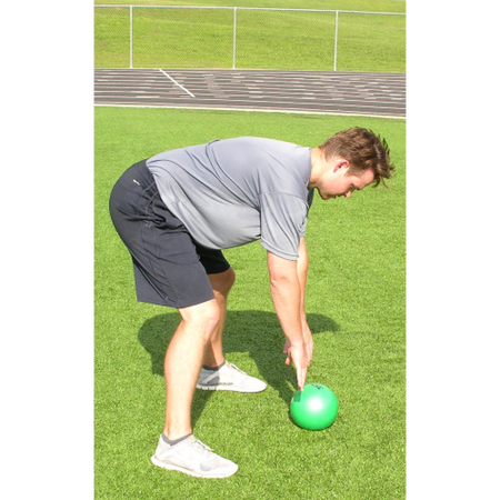 The green pummel ball rests on the ground after being slammed by an athlete.