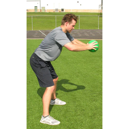 Athlete leans over, holding a green pummel ball with both hands in a side profile view.