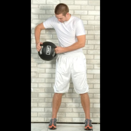 Double Handle Medicine Ball positioned beside an athlete’s hip—used for transitional movements targeting core stability and hip engagement during functional training.