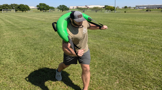An athlete with the Bulgarian Water Bag over his shoulders doing a rotational exercise.