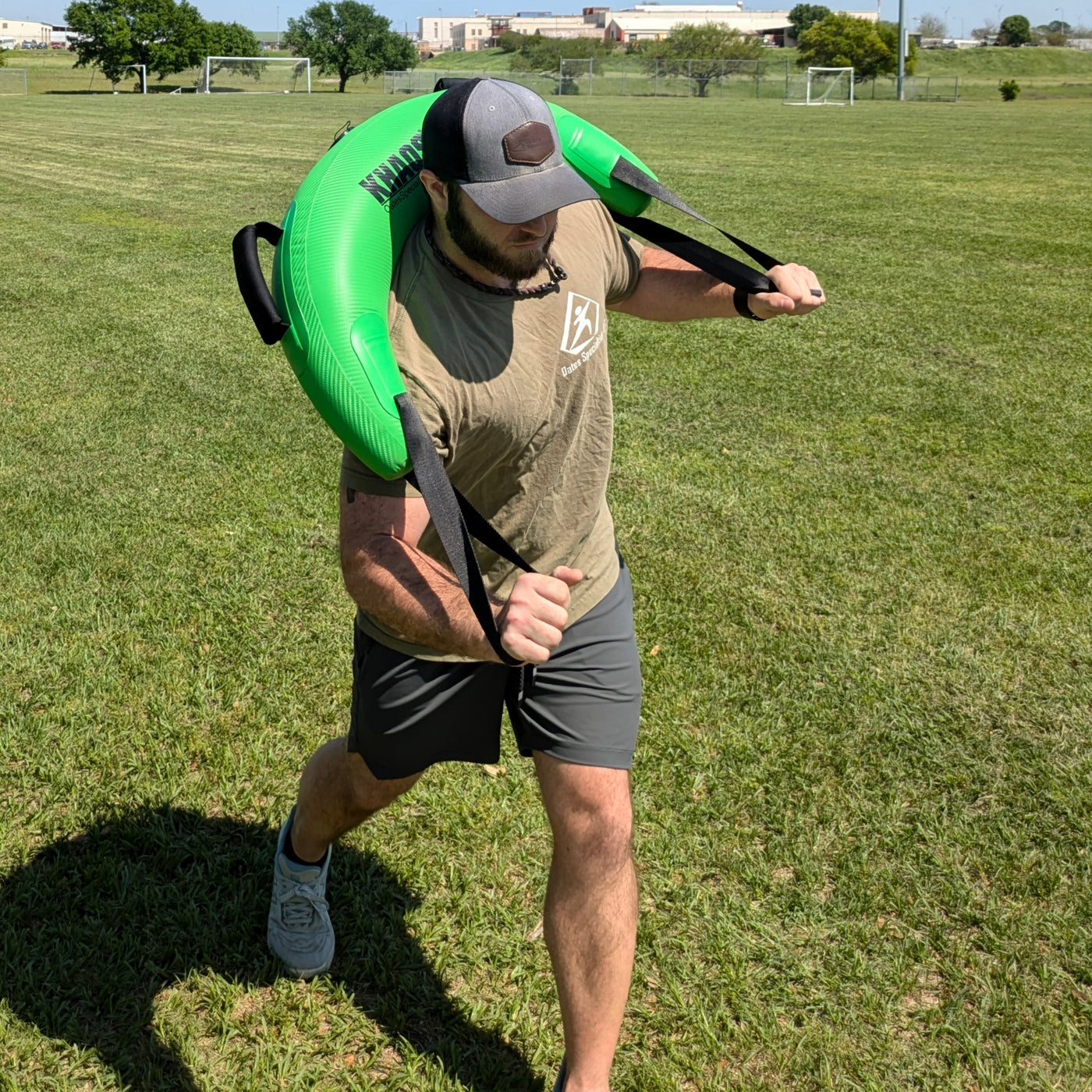 An athlete with the Bulgarian Water Bag over his shoulders doing a rotational exercise.