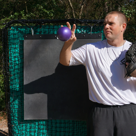 Athlete releasing a TAP® Mini-Medicine Ball in a reverse throw motion, targeting arm decelerator muscles for injury prevention.