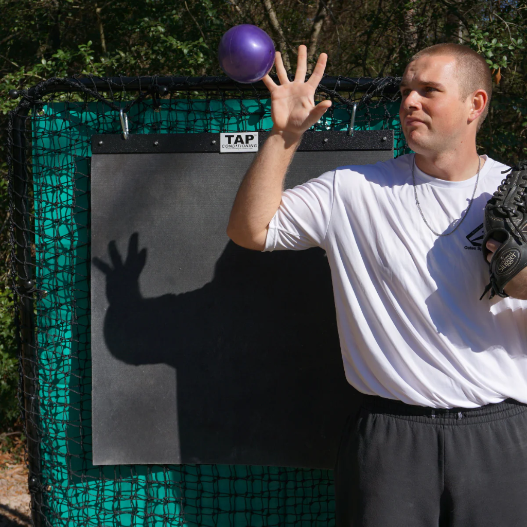 A TAP® Mini-Medicine Ball in the air, captured at the peak of a toss during a training exercise.