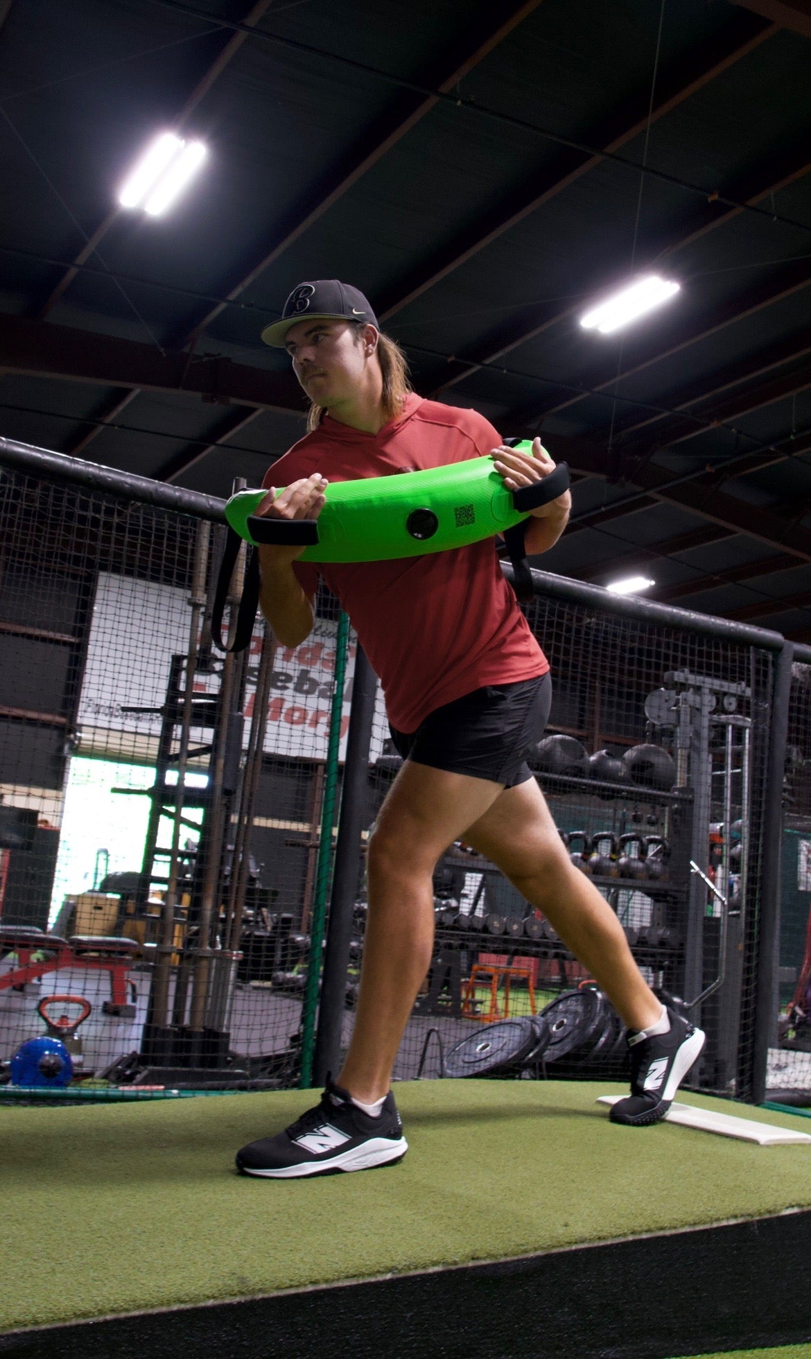 Side view of an athlete holding the Khaos® Bulgarian Water Bag against their chest during rotational core training. The dynamic water movement challenges stabilization, crucial for baseball pitching power and accuracy.