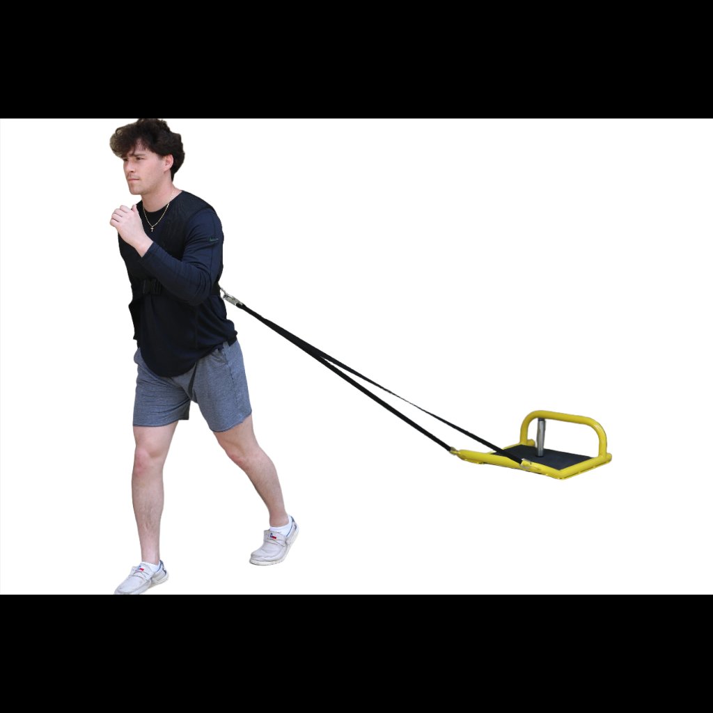 Athlete pulling resistance sled attached to body for lower body power development while using the included tow strap.