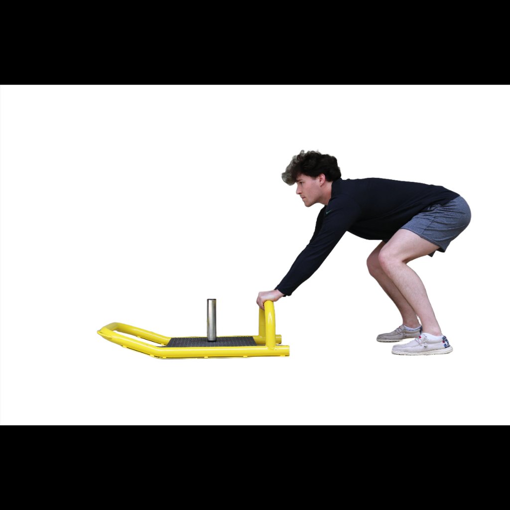 Athlete gripping resistance sled handles and dragging it toward the body to build lower body strength and core stability.