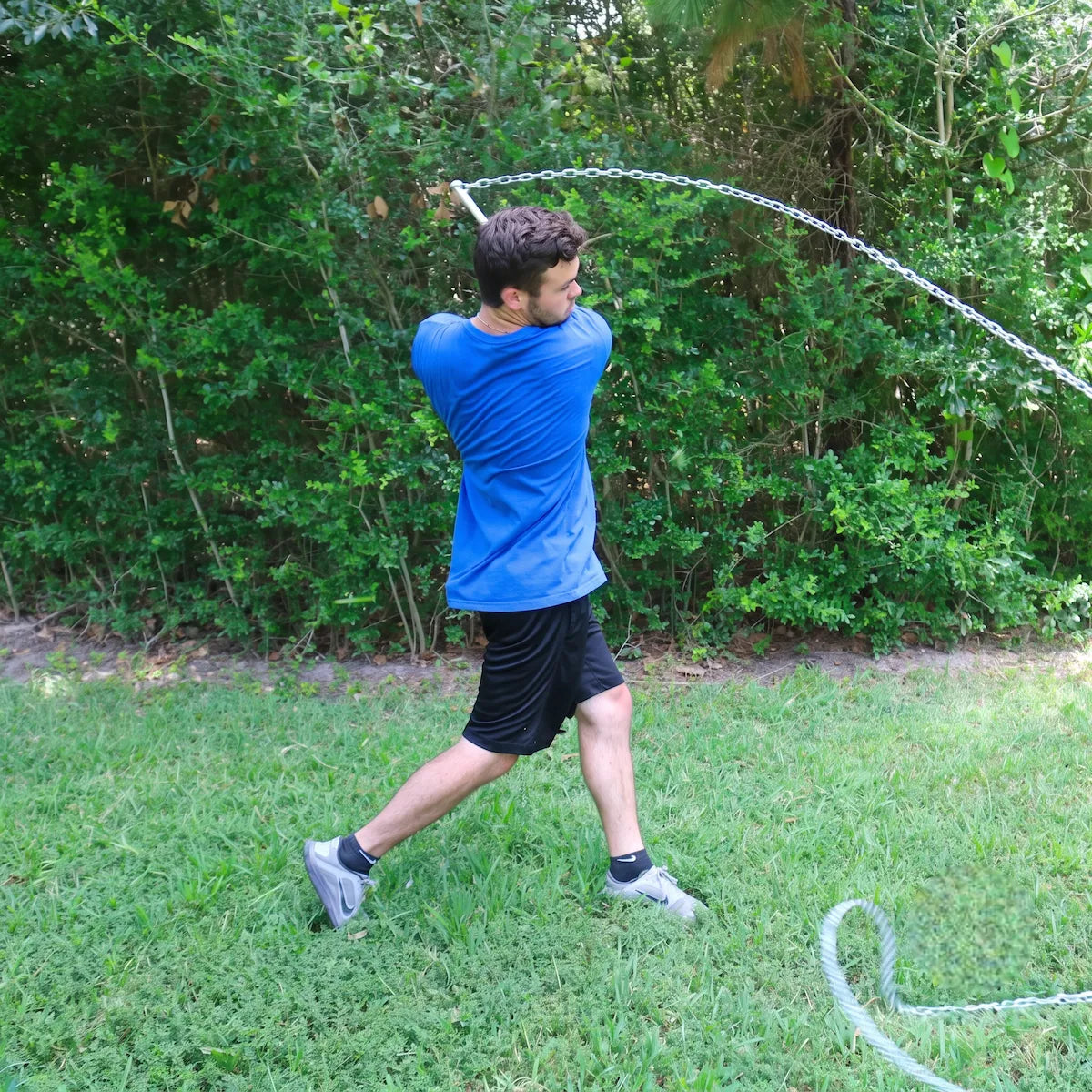 Baseball player finishing his swing with SpeedChain® Batting Chain, chain wrapping as the swing decelerates.