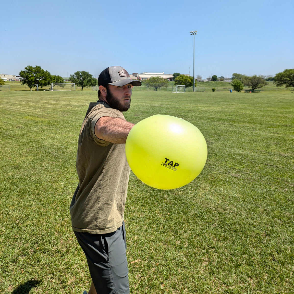 An athlete gripping the TAP® Connection Ball with the glove side hand to help the athlete feel what an efficient glove side movement pattern feels like.