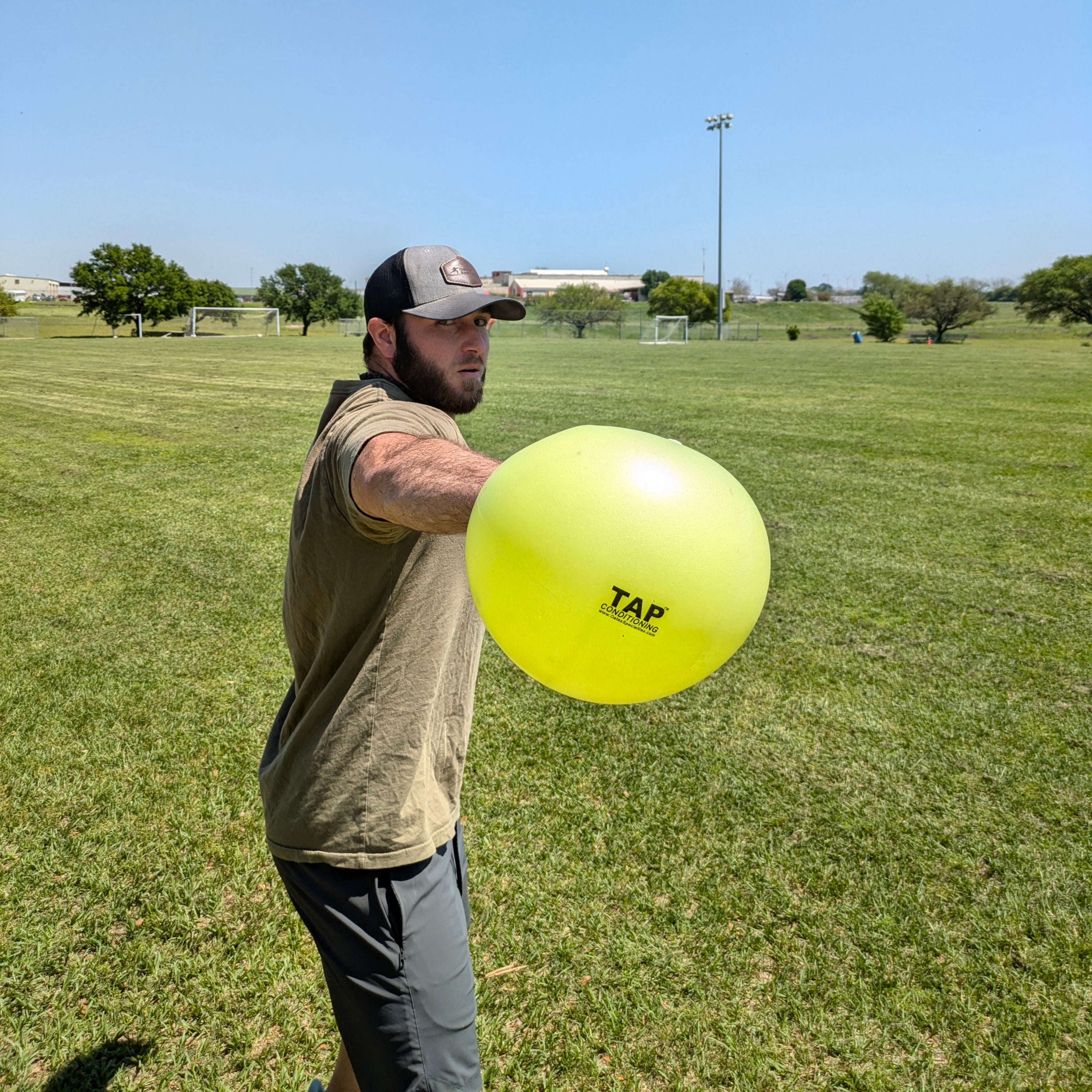 An athlete gripping the TAP® Connection Ball with the glove side hand to help the athlete feel what an efficient glove side movement pattern feels like.