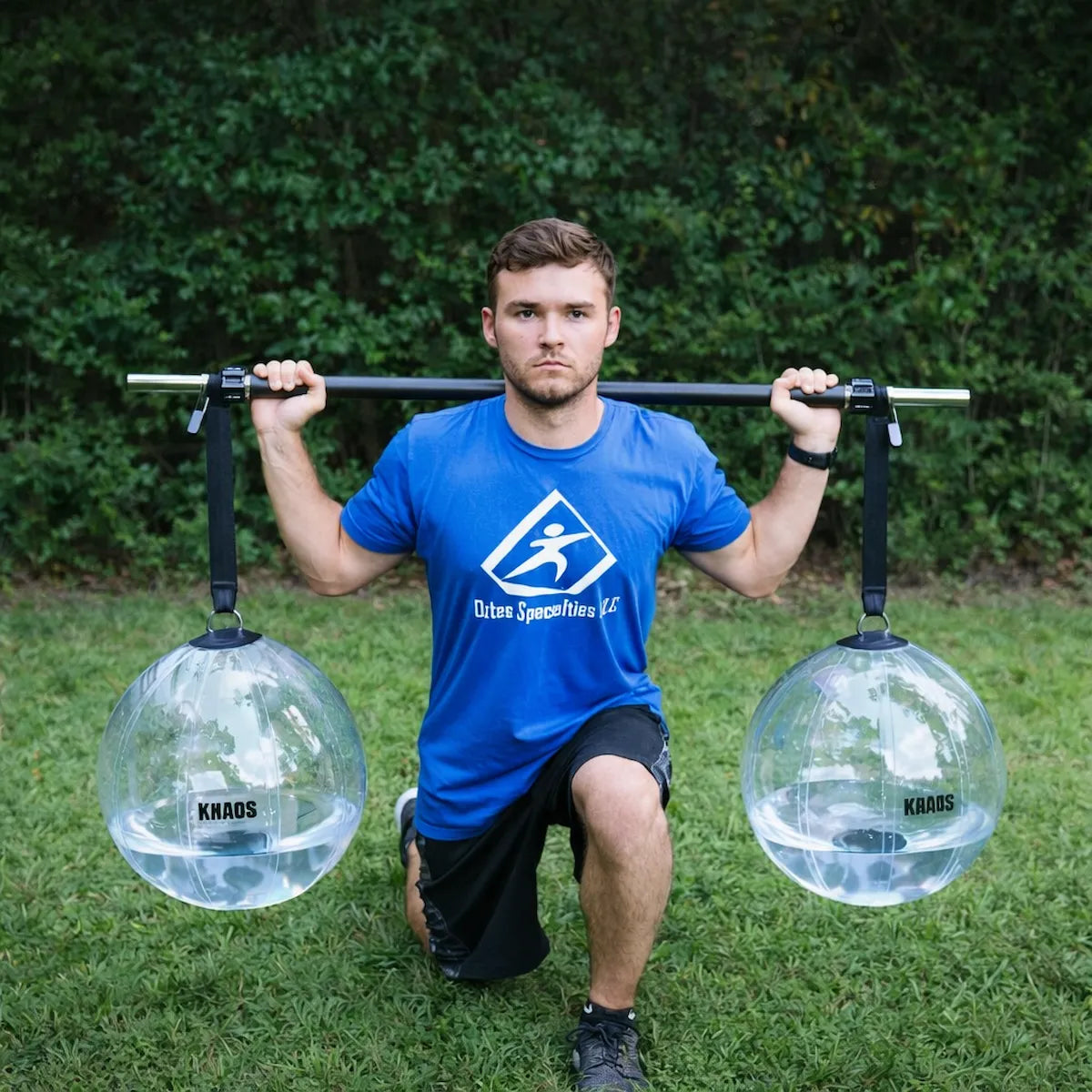 Athlete performing a lunge with the KHAOS® Yoke, utilizing suspended water balls to drive anterior-load stabilization and maximize force transmission through the throwing chain.