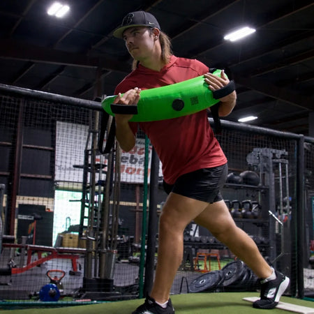 Athlete holding the KHAOS® Bulgarian Water Bag for rotational core training, utilizing dynamic water perturbations to build throwing arm stability and increased pitching power.
