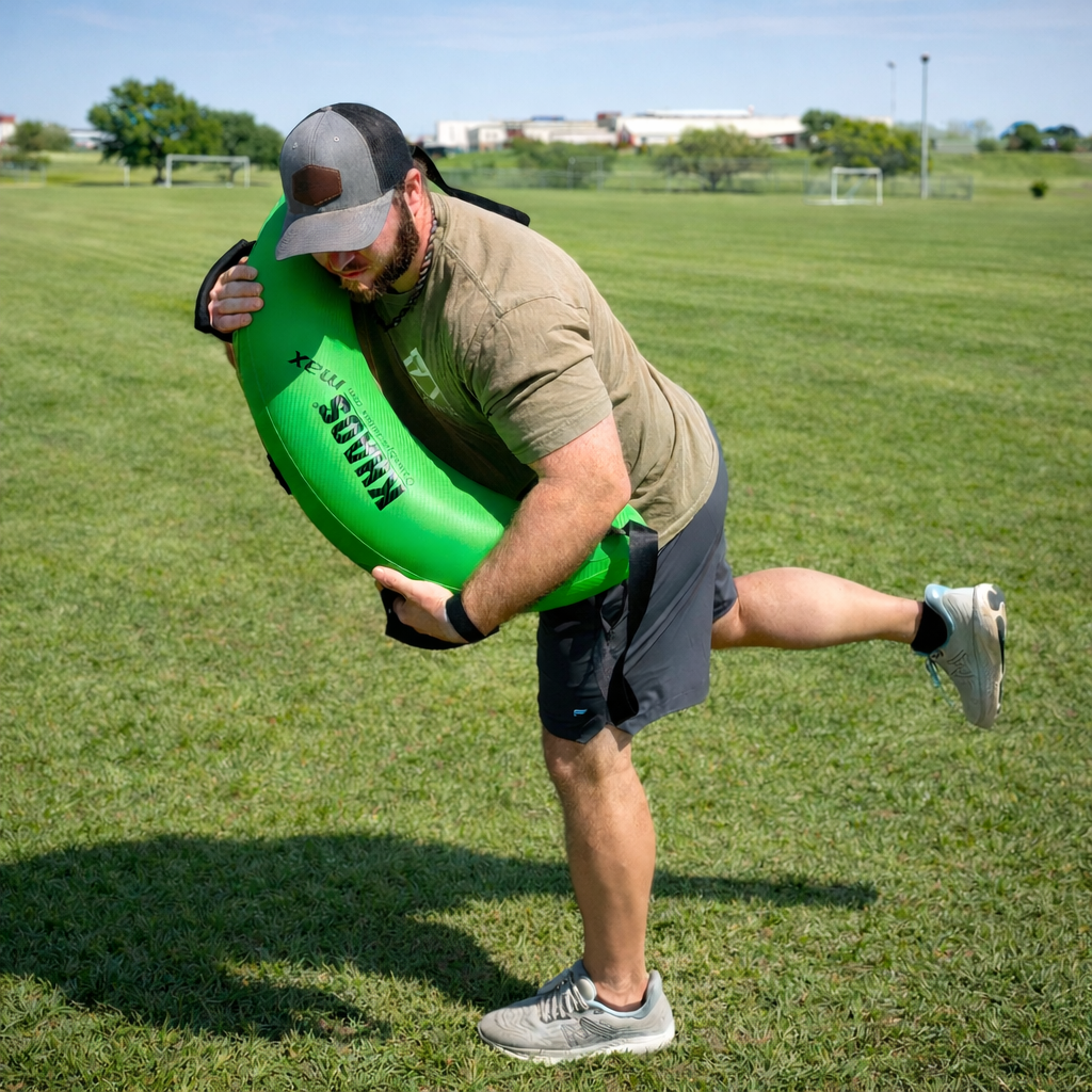 The athlete is crossing the KHAOS water bulgarian bag in front of his body from his right shoulder to his left hip. He is acting like he is finishing a pitch which forces the athlete to stabilize at landing in order to keep his balance.