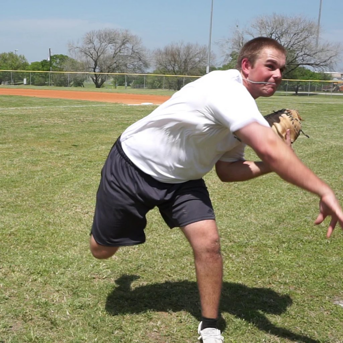 Catcher completing his follow-through after releasing a DTS weighted ball, demonstrating controlled mechanics and precision in a throw-down drill.