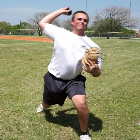 Catcher executing a catch and transfer with a DTS weighted training ball, utilizing a variable-load stimulus to drive kinetic chain organization and maximize force transmission through the throwing arm.