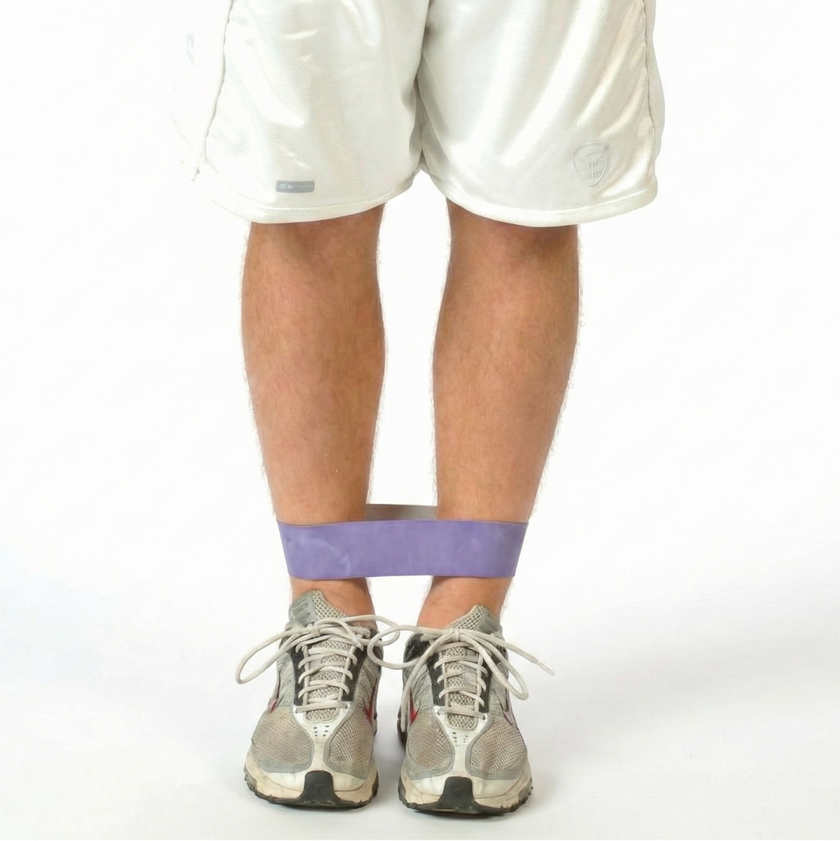 Athlete utilizing a TAP® Exercise Band for seated hip adductor isometrics to promote pelvic floor stability and targeted inner-thigh activation during the restoration phase of a training session.