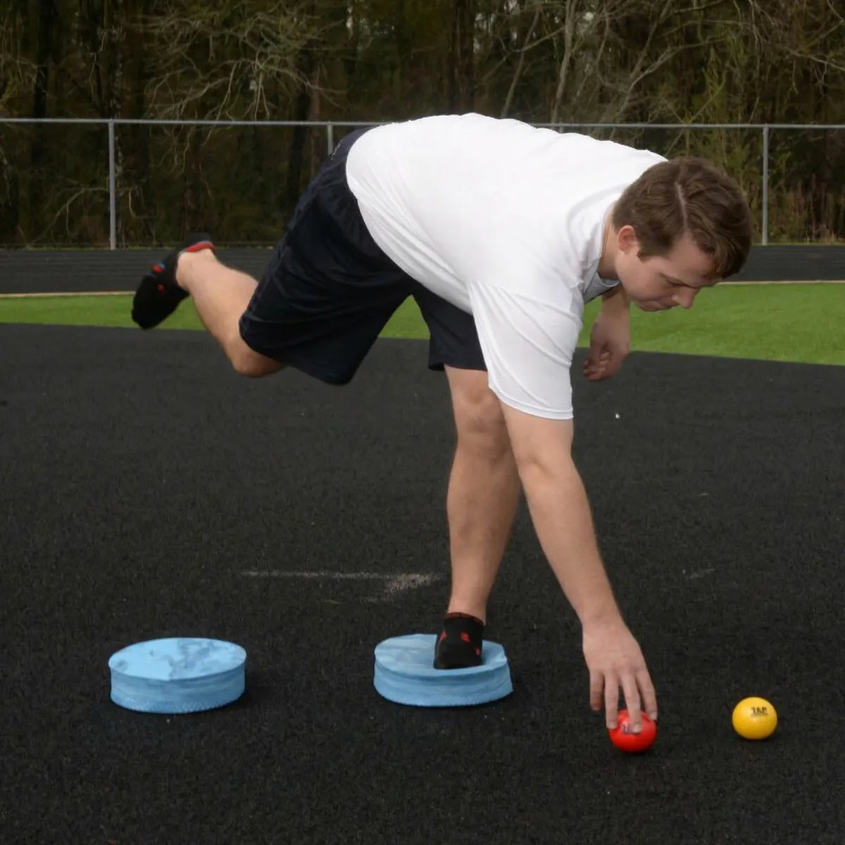 Athlete utilizing an Oval Balance Pad for lead-side stabilization and kinetic chain organization, creating an unstable variable stimulus for increased power.
