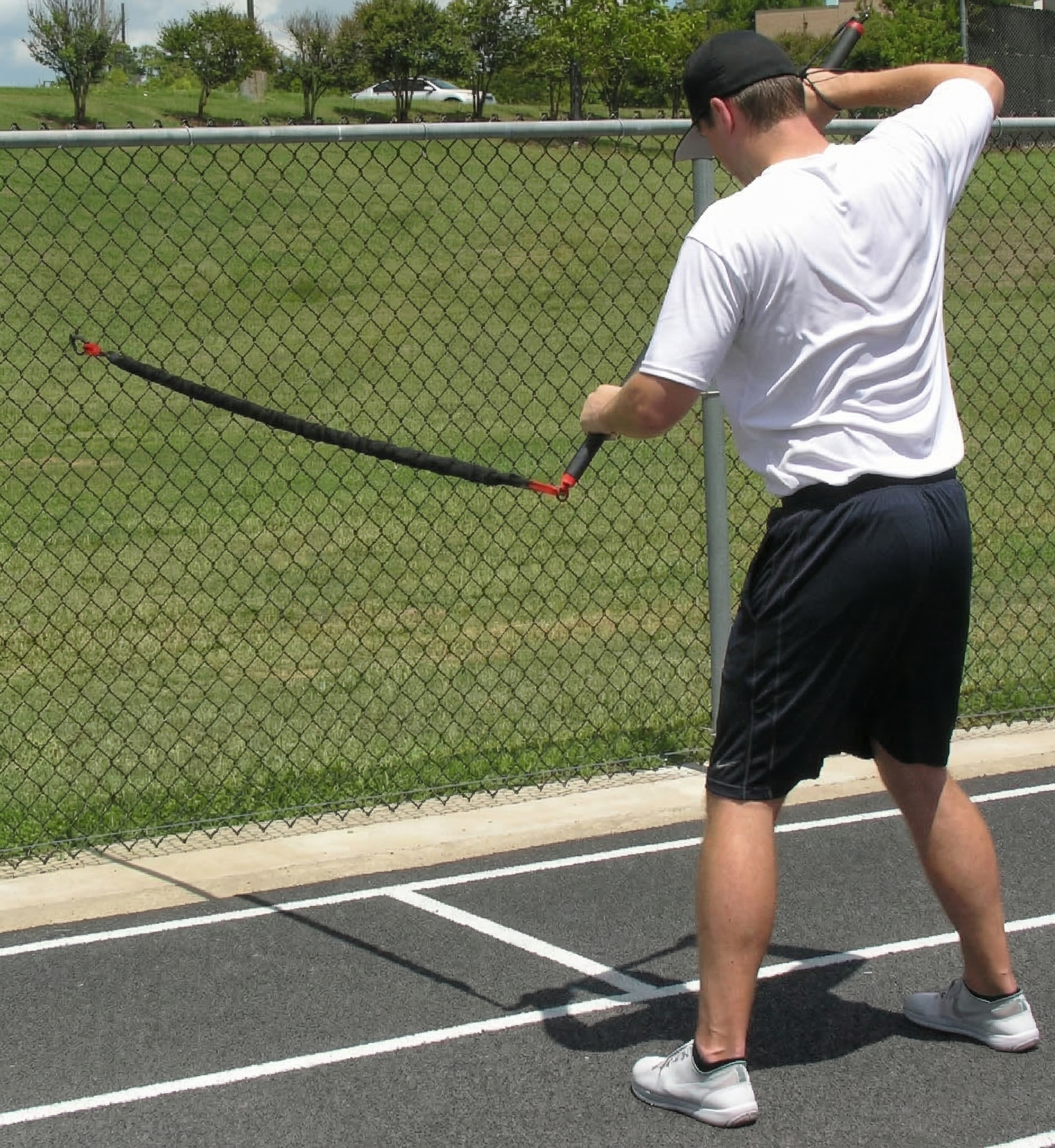 Athlete performing one-sided resisted rows with the KHAOS Pivoter, utilizing elastic rhythmic perturbations to drive lead-side stabilization and kinetic chain organization for increased power.