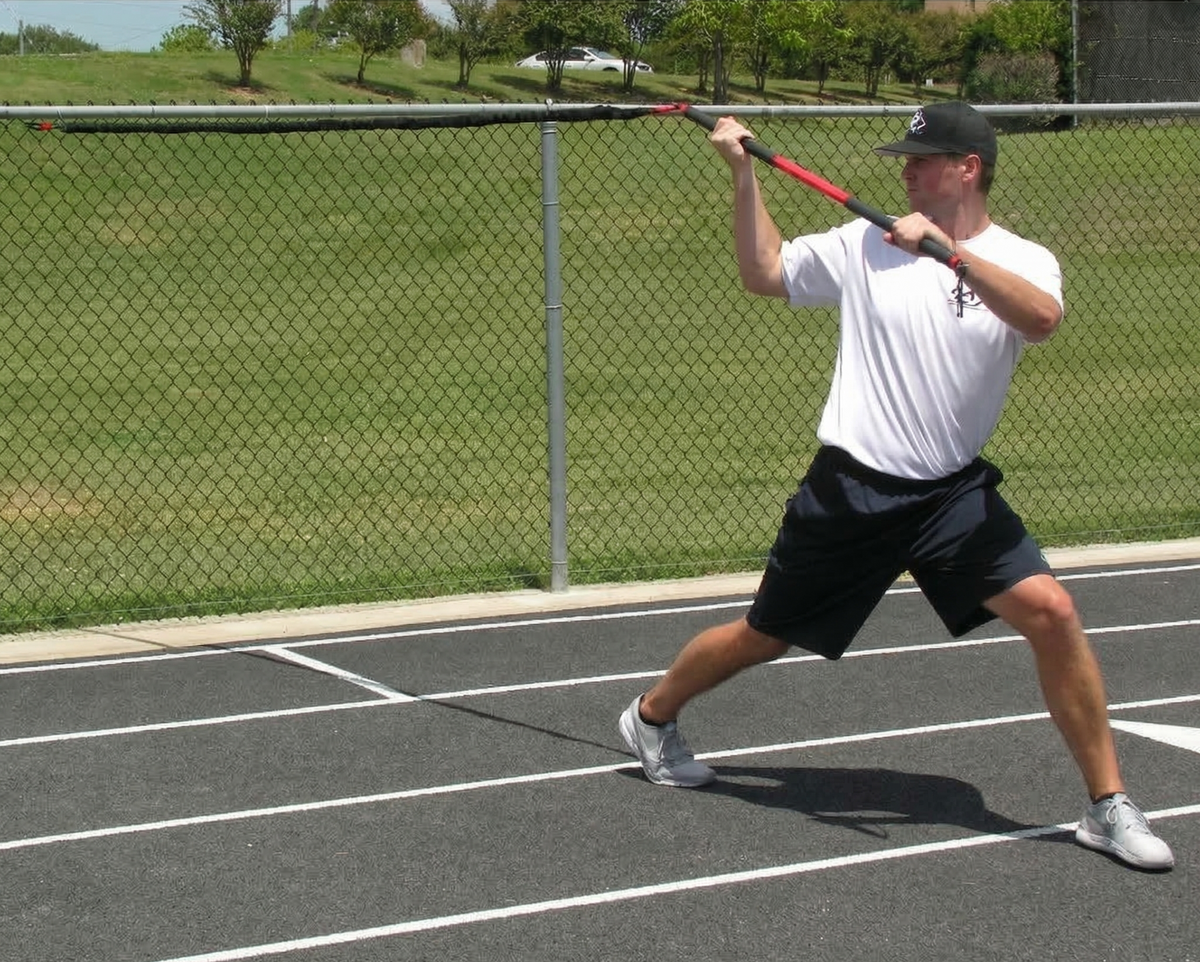 Athlete performing an over-the-shoulder wood chopper with the KHAOS Pivoter, utilizing elastic rhythmic perturbations to drive lead-side stabilization and kinetic chain organization for increased power.