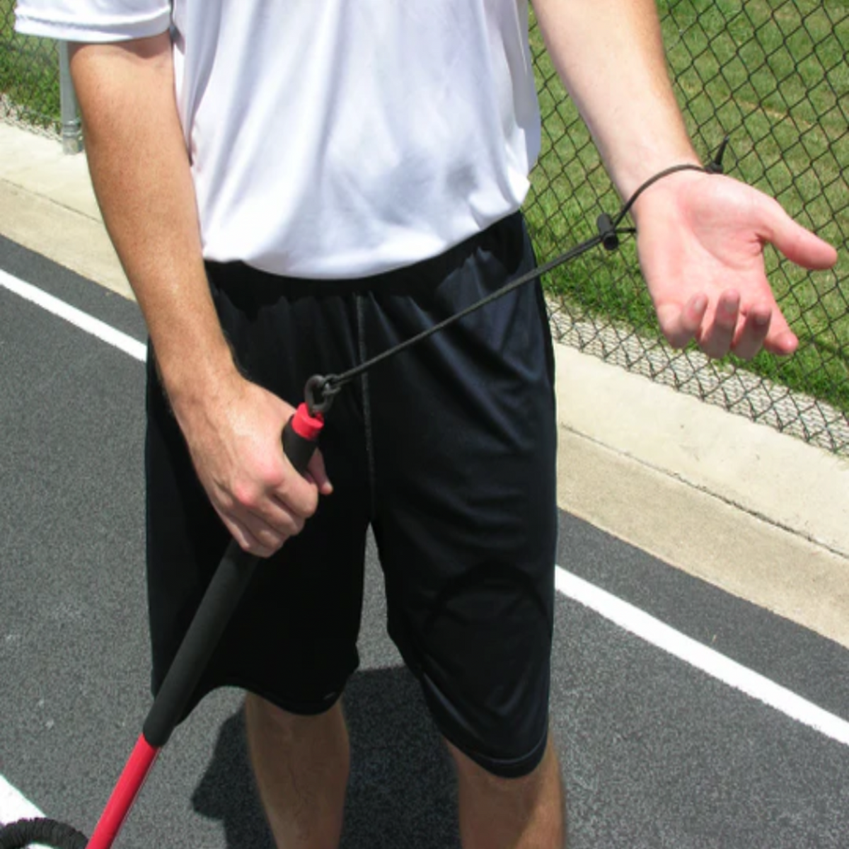 Athlete securing the Safety Wrist Strap of the KHAOS Pivoter, ensuring a secure connection to the 2-piece industrial-grade bar for lead-side stabilization and kinetic chain organization.