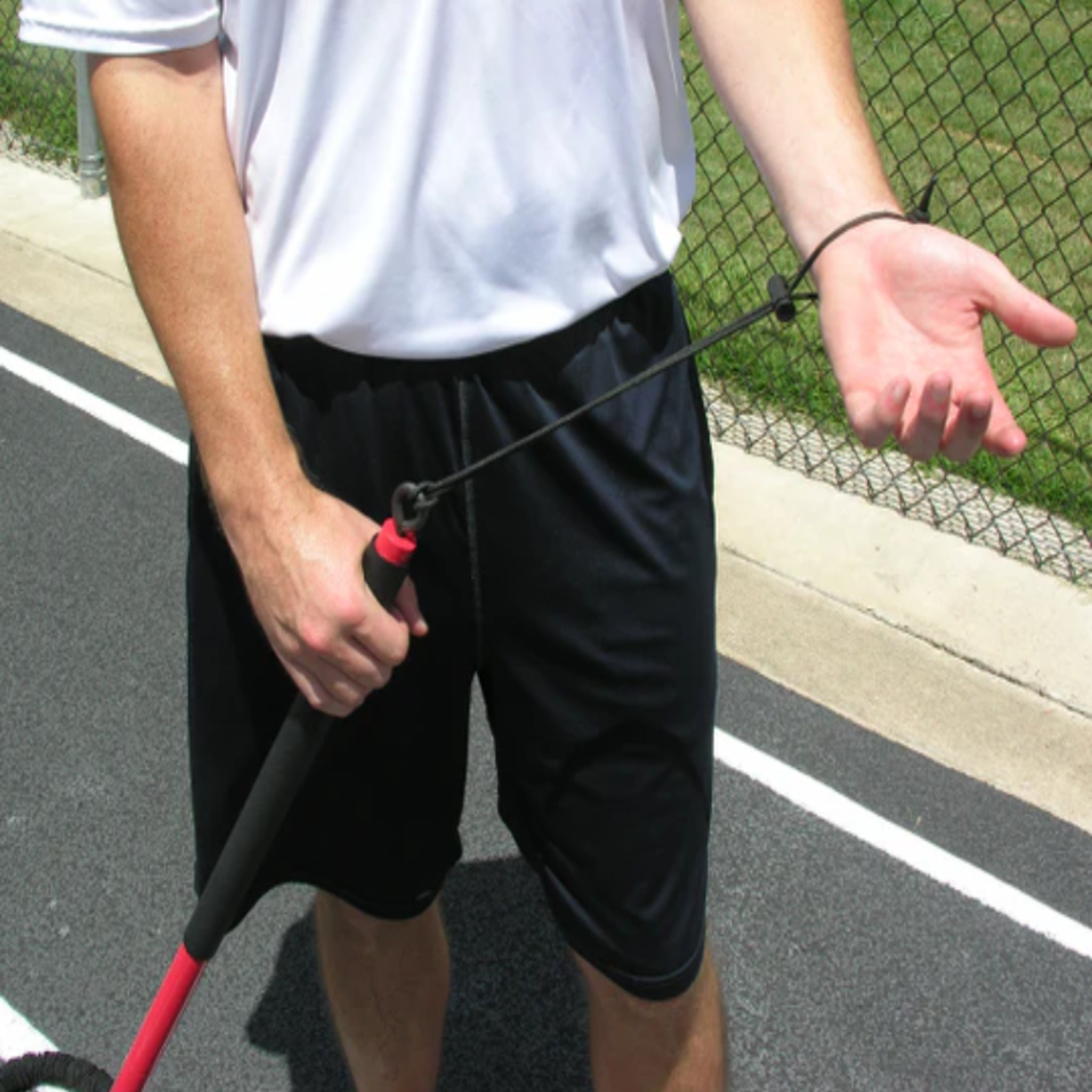 Athlete securing the Safety Wrist Strap of the KHAOS Pivoter, ensuring a secure connection to the 2-piece industrial-grade bar for lead-side stabilization and kinetic chain organization.