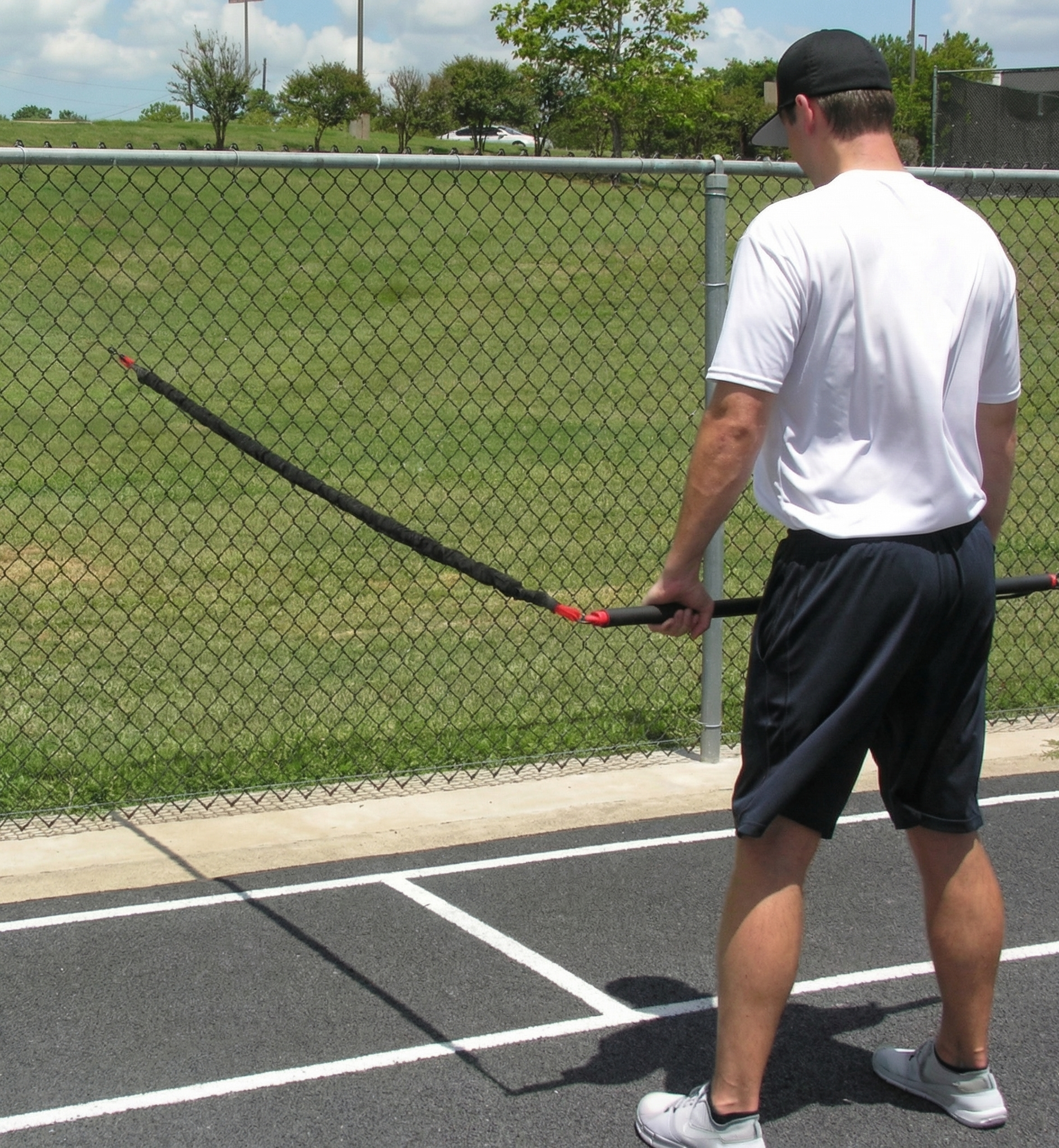 Athlete performing a dynamic resistance drill with the KHAOS Pivoter, utilizing elastic rhythmic perturbations to drive lead-side stabilization and kinetic chain organization for increased power.