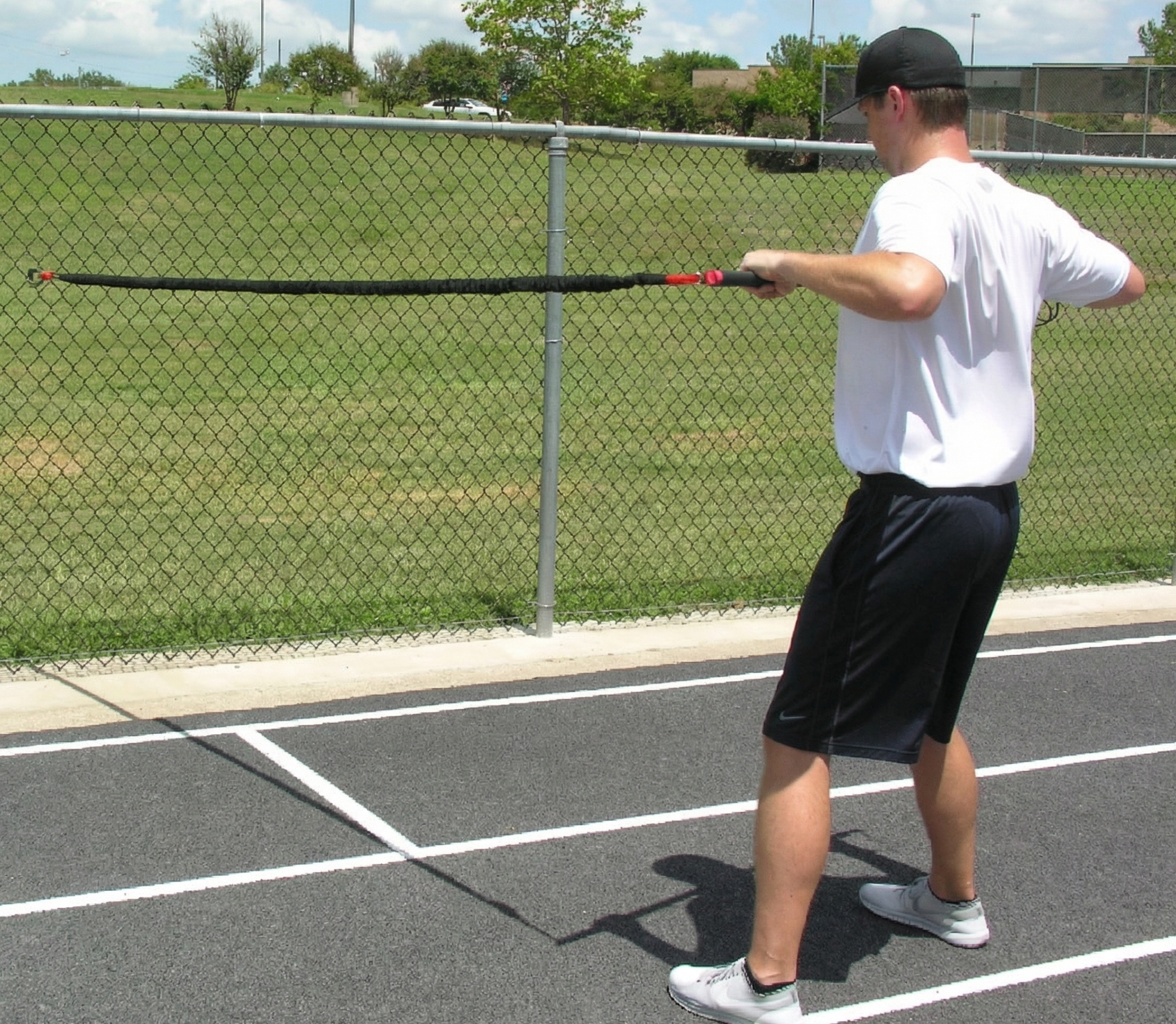 Athlete performing a one-sided resisted chest pull with the KHAOS Pivoter, utilizing elastic rhythmic perturbations to drive lead-side stabilization and kinetic chain organization for increased power.