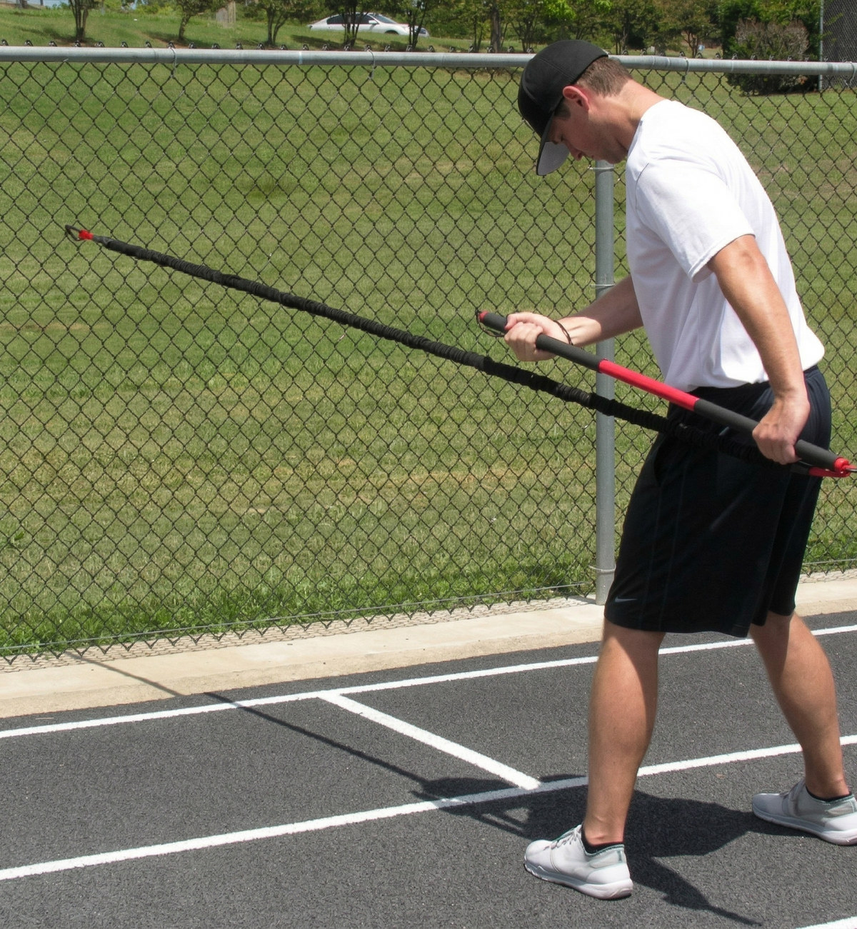 Athlete performing an extended resisted row with the KHAOS Pivoter, utilizing elastic rhythmic perturbations to drive lead-side stabilization and kinetic chain organization for increased power.