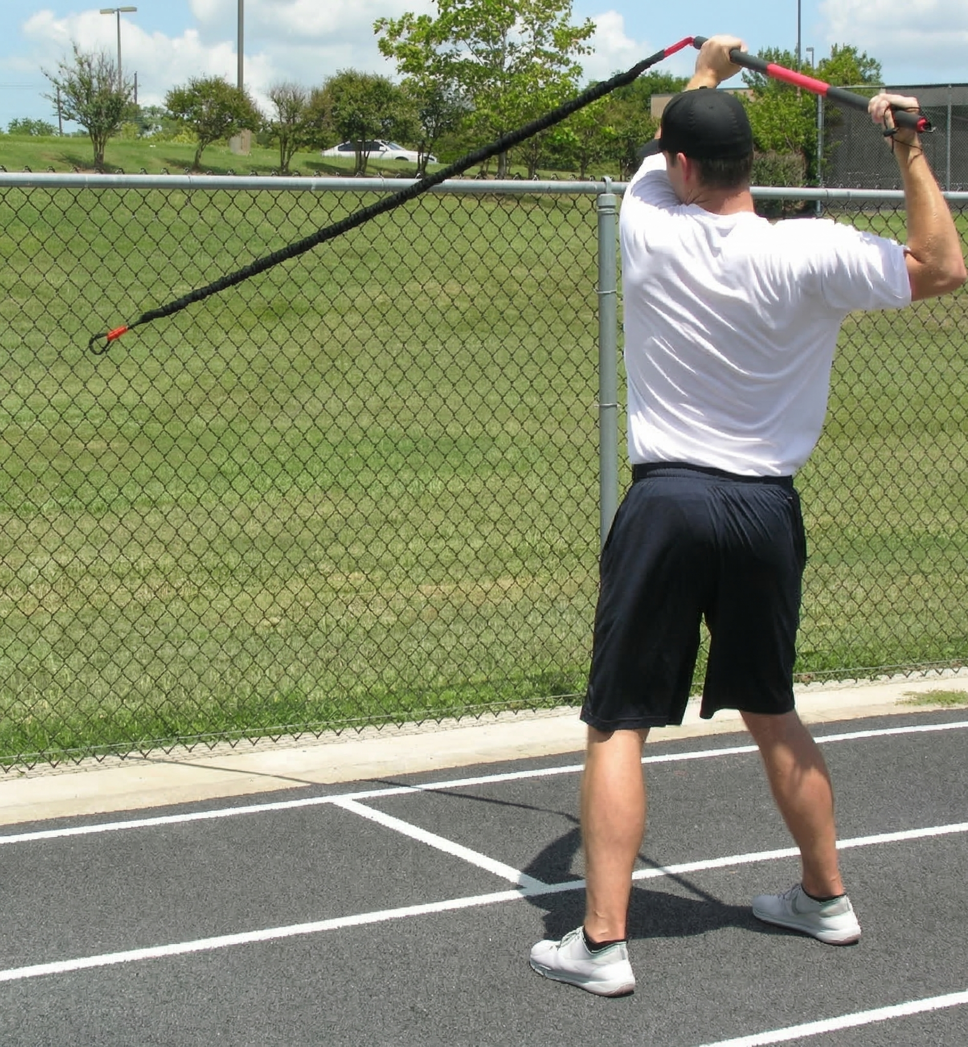 Athlete performing rear resisted rows with the KHAOS Pivoter, utilizing elastic rhythmic perturbations to drive lead-side stabilization and kinetic chain organization for increased power.