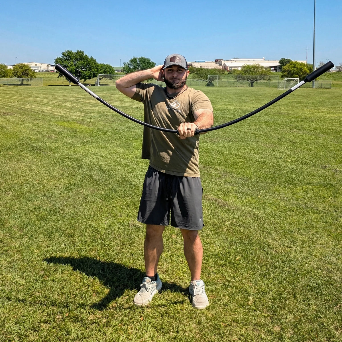 Athlete performing a front-facing rhythmic stabilization drill with the TAP® Shoulder Tube. Moving the device in a vertical plane with a pronated grip (palms down) creates oscillatory waves that drive scapular protraction and intensive anterior deltoid activation.