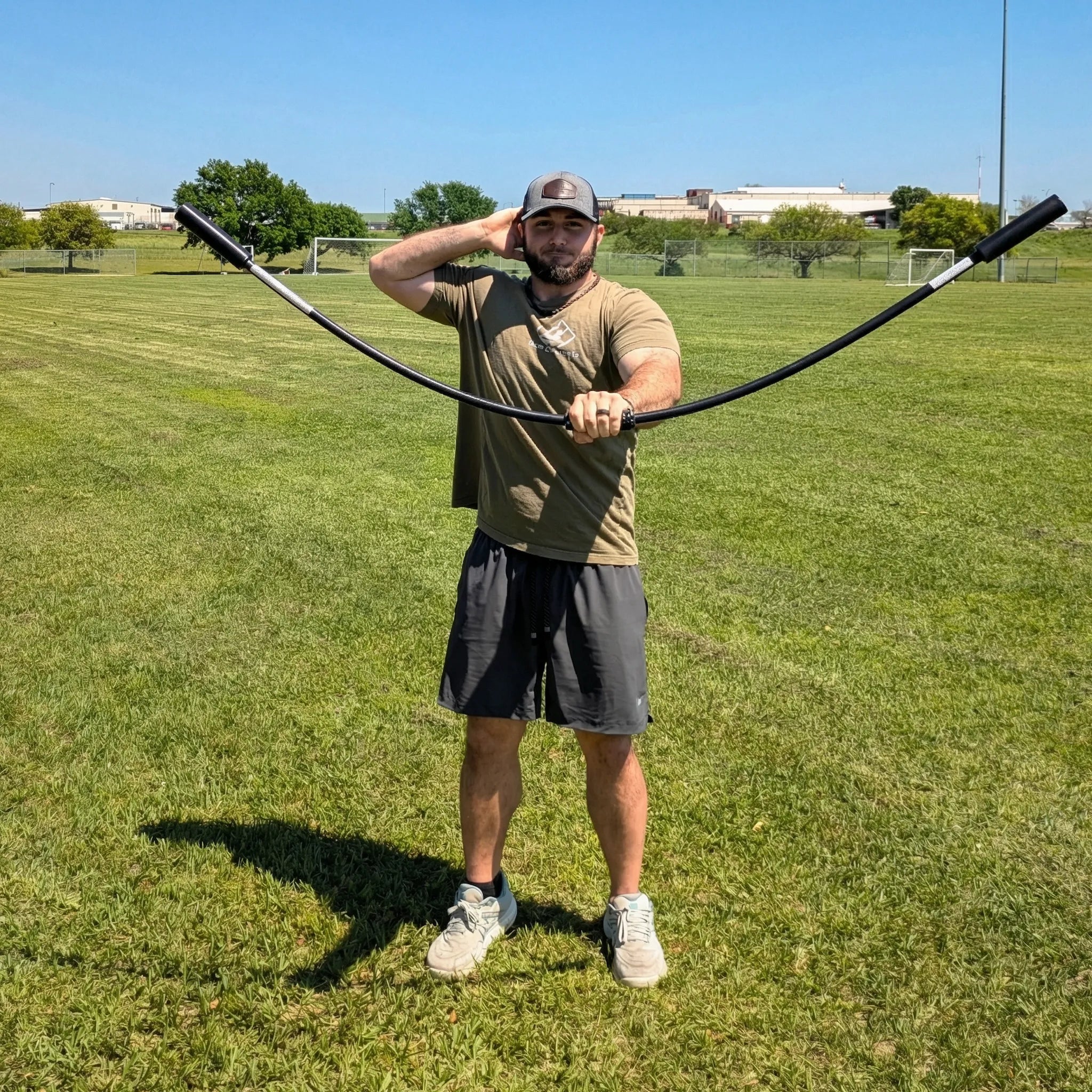 Athlete performing a front-facing rhythmic stabilization drill with the TAP® Shoulder Tube. Moving the device in a vertical plane with a pronated grip (palms down) creates oscillatory waves that drive scapular protraction and intensive anterior deltoid activation.