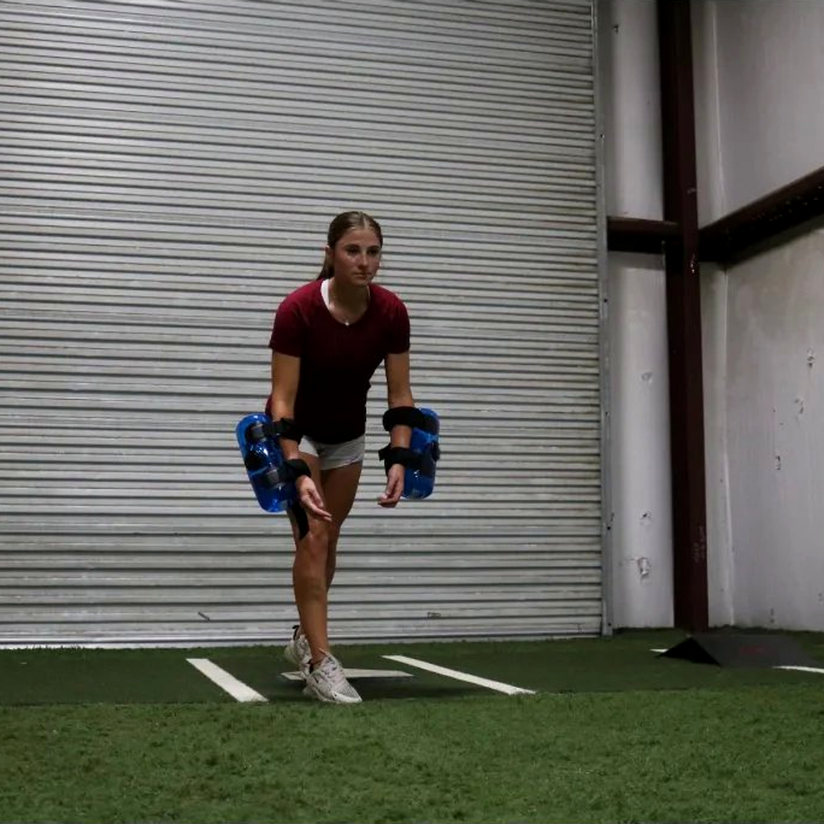 Athlete in ready position with KHAOS® Waterboy Jr strapped to arms, driving forward to generate water instability, enhancing strength, control, and dynamic resistance training.