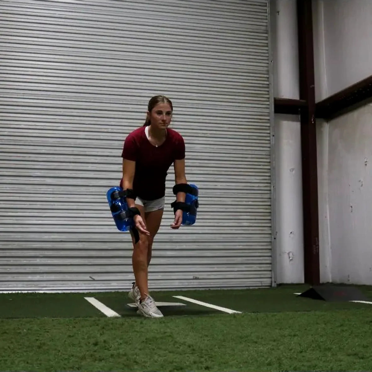 Athlete driving from a lead-leg block with KHAOS® Waterboy Jr. tubes to drive kinetic chain organization and maximize power transfer via dynamic water perturbations.
