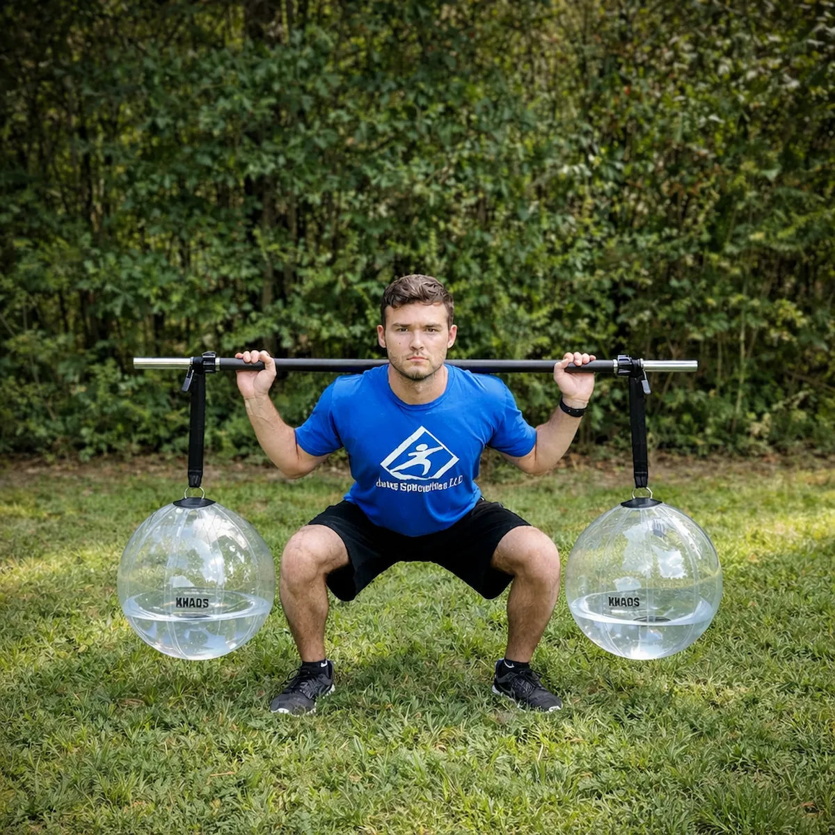Athlete performing a squat with the KHAOS® Yoke, utilizing suspended water balls to drive lead-leg stabilization and maximize force transmission through the kinetic chain.