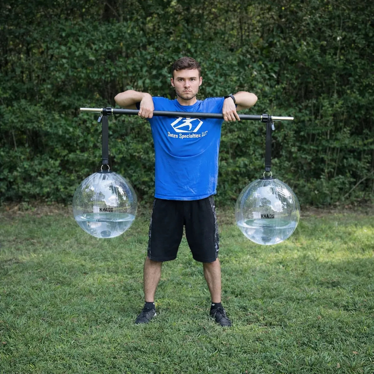 Athlete performing an upright row with the KHAOS® Yoke, utilizing suspended water perturbations to drive scapular stabilization and build increased power in the throwing arm.