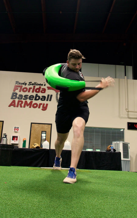 Athlete at the Florida Baseball ARMory utilizing the Khaos® Bulgarian Water Bag to strengthen core muscles crucial for baseball pitching. The shifting water provides an unstable load, improving balance and rotational power.