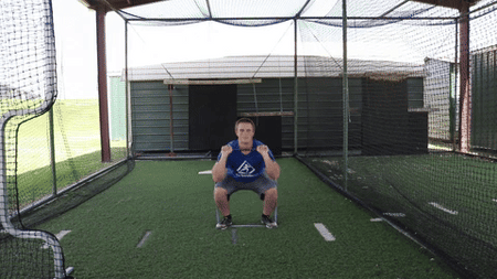An athlete performs a squat into a military press for full body resistance training with the Green Giant Flat Band.