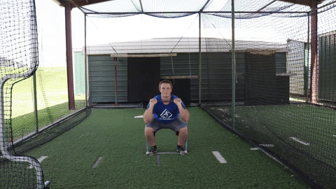An athlete performs a squat into a military press for full body resistance training with the Green Giant Flat Band.