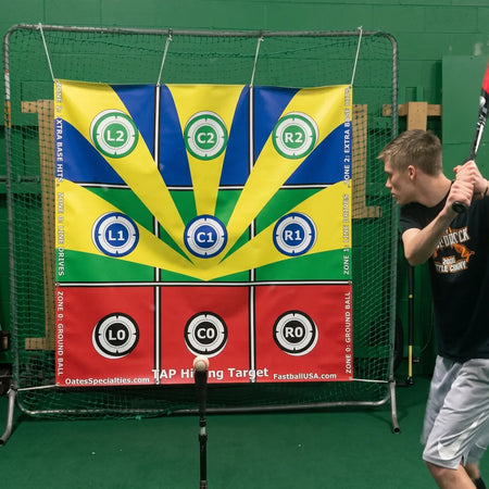 Baseball hitter in stance beside a colorful TAP® Hitting Target banner mounted on a net with nine labeled zones and a ball on a batting tee, ready to practice precision contact and launch angle control.