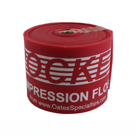 TAP® Rocket Wrap red Heavy compression floss band rolled tightly, highlighting heavy resistance level, compact design, and durable natural latex material for post‑throw recovery.