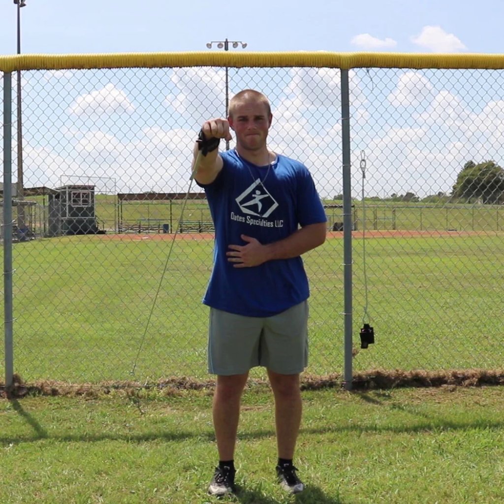 An athlete extending his arm in a punching motion to improve scapular strength and health using the Pitcher's Friend tubing.