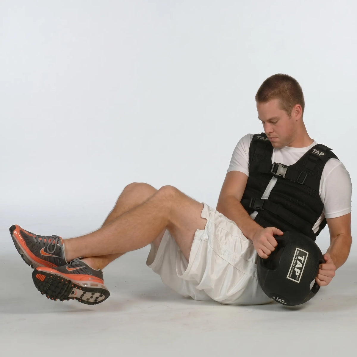 Athlete performing Russian twists with a Double Handle Medicine Ball—engaging core muscles through rotational movement for strength and stability training.