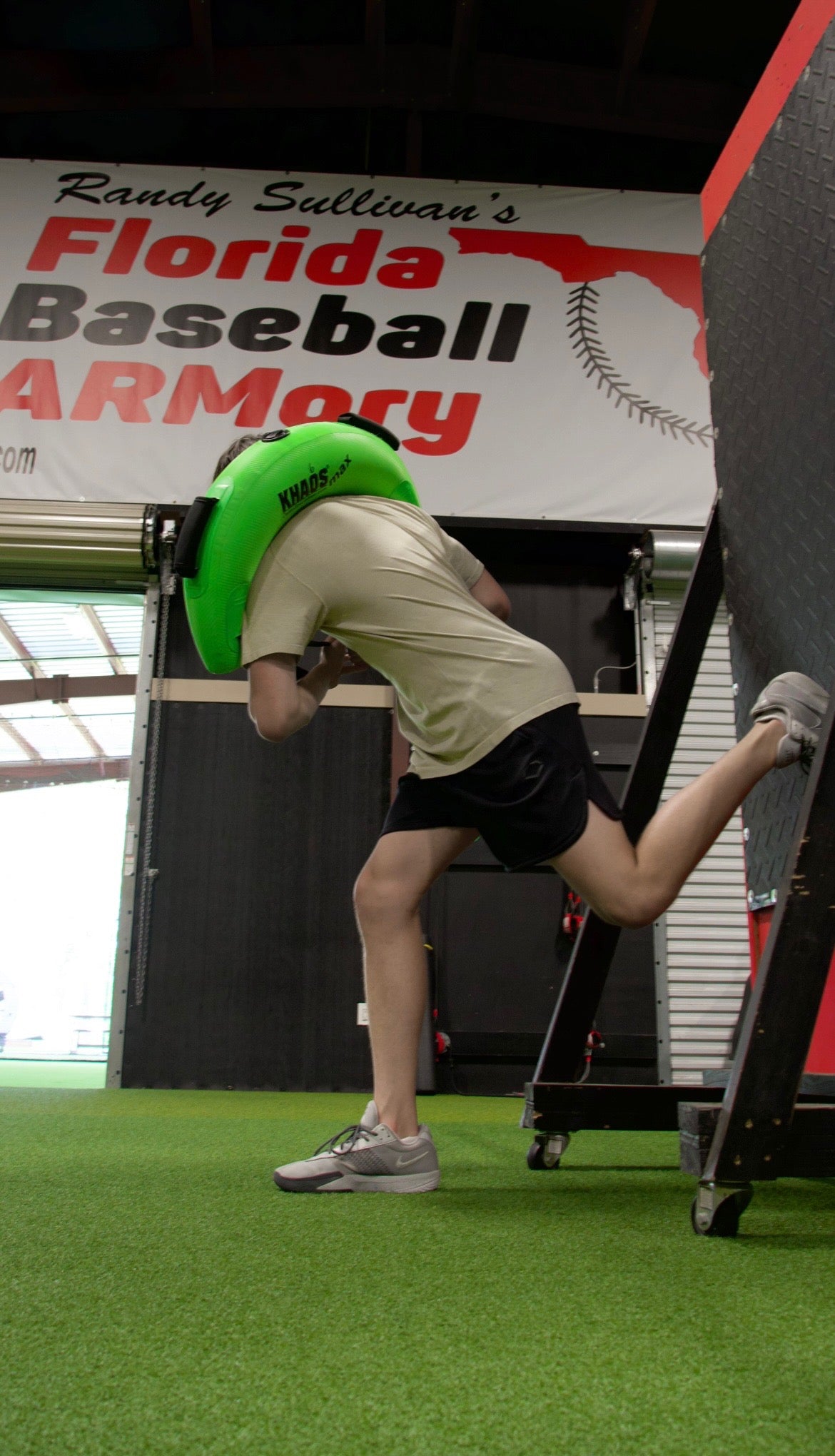 Athlete at Florida Baseball ARMory using the Khaos Bulgarian Water Bag for focused core and leg stabilization training. Bracing against a wall enhances targeted muscle engagement for improved pitching performance.