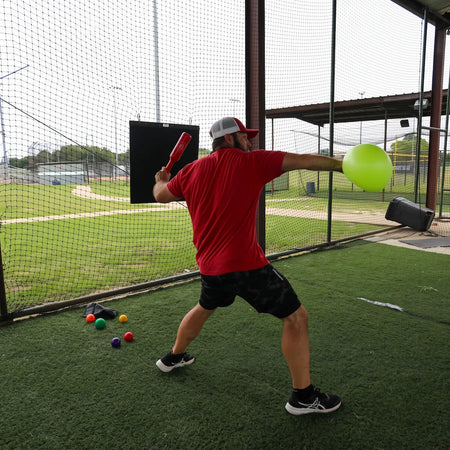 Athlete utilizing the TAP® Connection Throwing Club and TAP® Connection Ball simultaneously for dual-load organization and kinetic chain organization to build throwing arm power.